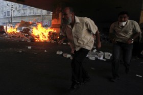 Supporters of deposed President Mohamed Mursi run for cover during clashes in front of Azbkya police station at Ramses Square in Cairo