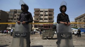 Riot police guard the site of an explosion near the house of Egypt's interior minister at Cairo's Nasr City district