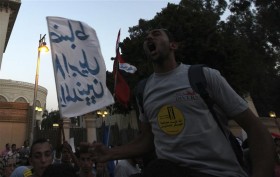 An Egyptian protester shouts slogans to demand the release of political prisoners arrested by the military over the last 18 months, in front of the presidential palace in Cairo